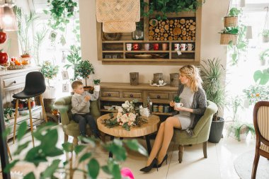 Anne ve kızı caffe çiçeklerle. Evlat annesine çiçek ver. sevimli bir aile. Dünya Kadınlar günü 8 Mart kutluyor