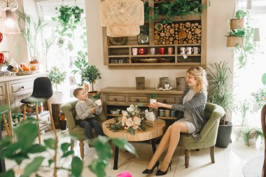 Anne ve kızı caffe çiçeklerle. Evlat annesine çiçek ver. sevimli bir aile. Dünya Kadınlar günü 8 Mart kutluyor