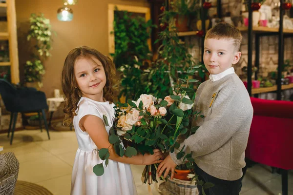 Anne ve kızı caffe çiçeklerle. Evlat annesine çiçek ver. sevimli bir aile. Dünya Kadınlar günü 8 Mart kutluyor