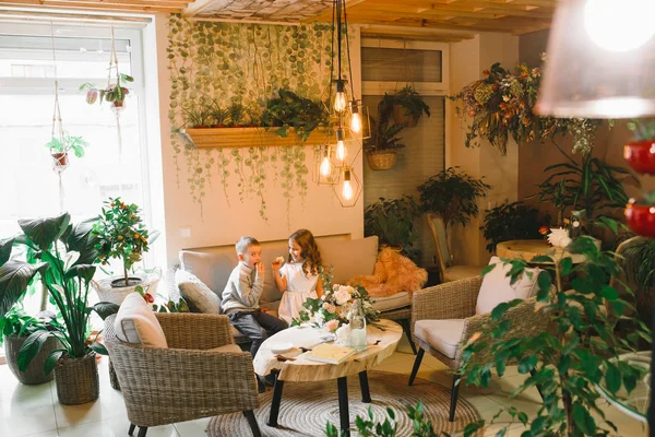 Anne ve kızı caffe çiçeklerle. Evlat annesine çiçek ver. sevimli bir aile. Dünya Kadınlar günü 8 Mart kutluyor