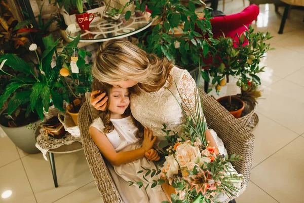 Anne ve kızı caffe çiçeklerle. Evlat annesine çiçek ver. sevimli bir aile. Dünya Kadınlar günü 8 Mart kutluyor