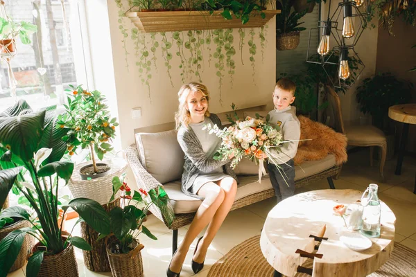 Anne ve kızı caffe çiçeklerle. Evlat annesine çiçek ver. sevimli bir aile. Dünya Kadınlar günü 8 Mart kutluyor