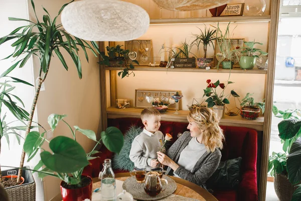 Anne ve kızı caffe çiçeklerle. Evlat annesine çiçek ver. sevimli bir aile. Dünya Kadınlar günü 8 Mart kutluyor