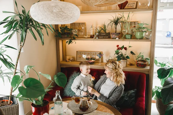 Anne ve kızı caffe çiçeklerle. Evlat annesine çiçek ver. sevimli bir aile. Dünya Kadınlar günü 8 Mart kutluyor