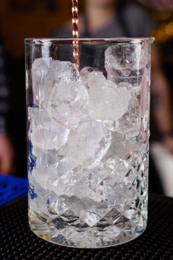 Uzman barmen gece kulübünde kokteyl yapıyor, barmen bir kokteyl elinde tutuyor. Yüzü yok. Seçici odak