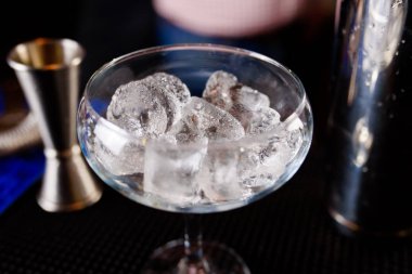 Uzman barmen gece kulübünde kokteyl yapıyor, barmen bir kokteyl elinde tutuyor. Yüzü yok. Seçici odak