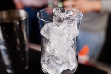 Uzman barmen gece kulübünde kokteyl yapıyor, barmen bir kokteyl elinde tutuyor. Yüzü yok. Seçici odak