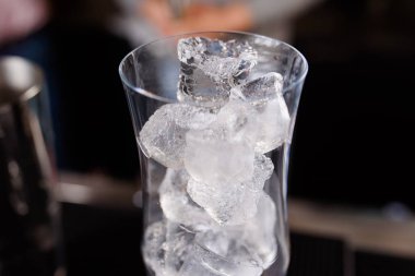 Uzman barmen gece kulübünde kokteyl yapıyor, barmen bir kokteyl elinde tutuyor. Yüzü yok. Seçici odak