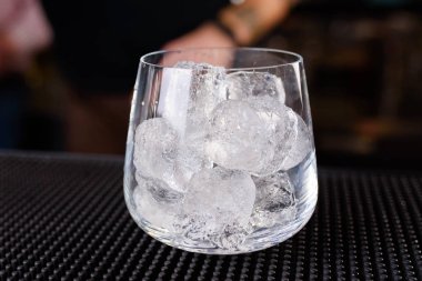 Uzman barmen gece kulübünde kokteyl yapıyor, barmen bir kokteyl elinde tutuyor. Yüzü yok. Seçici odak
