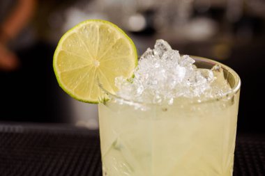 Uzman barmen gece kulübünde kokteyl yapıyor, barmen bir kokteyl elinde tutuyor. Yüzü yok. Seçici odak