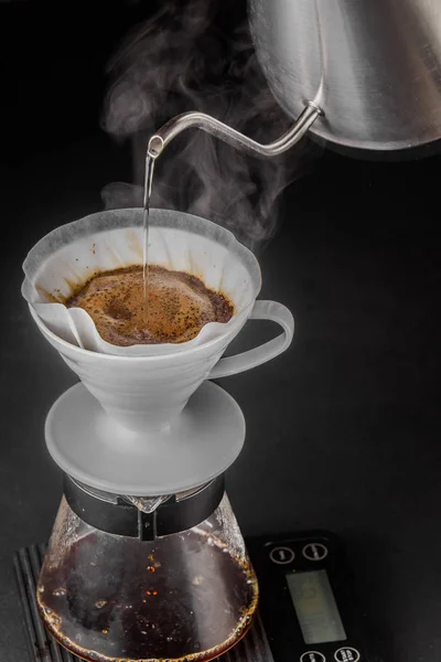 Kahve yapımında alternatif yöntem. kahve makinesi manuel dökme tarzı cam. Cofee siyah arka plan üzerinde bira