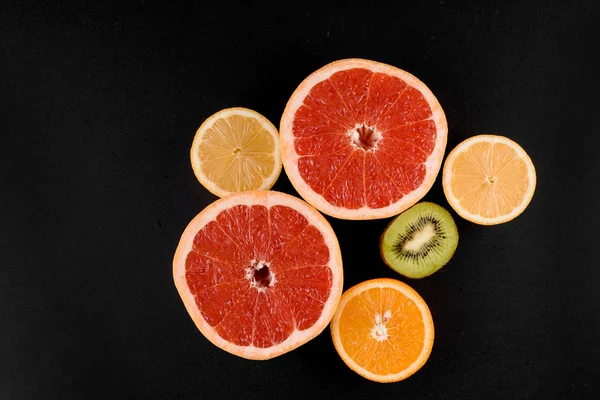 Mistura de laranja, kiwi, toranja em fundo preto. Frutas cítricas. Comida saudável de frescura. Fruta de laranja com vitamina — Fotografia de Stock