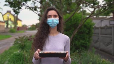 Suşi, arabayla sağlıklı yemek servisi kutusuna kondu. Suşi kutularıyla tıbbi maskeli kız kurye arabanın önünde duruyor. Japon mutfağı: ekmek, soya sosu, wasabi. Paket yemek reklamı