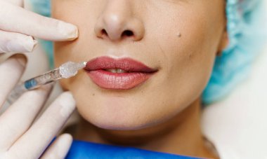 Çekici bir kız için dudak büyütme iğneleri. Estetik cerrah tıbbi klinikte dudağına iğne yapar. Kozmetik yenileme yüz tedavisi. Reklam için boş alan