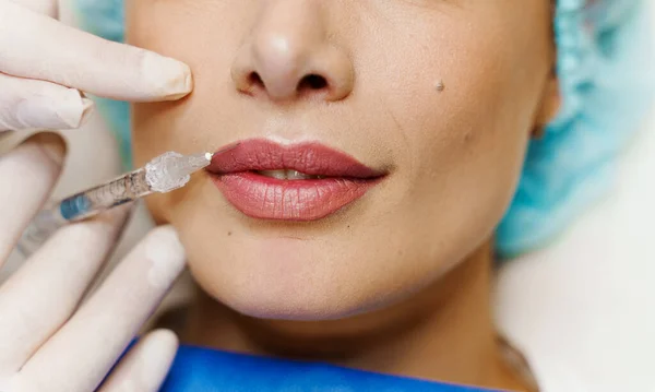 Çekici bir kız için dudak büyütme iğneleri. Estetik cerrah tıbbi klinikte dudağına iğne yapar. Kozmetik yenileme yüz tedavisi. Reklam için boş alan