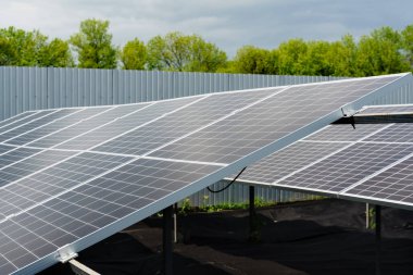 Güneş hücreleri yakın çekim. Alternatif güneş panelleri enerji santrali. Gezegenin sürdürülebilirliği. Ev için yeşil enerji. Güneş mavisi elektrik modülleri yerde duruyor.