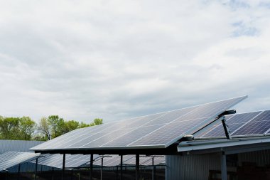 Güneş panelleri çatıda sıra halinde duruyor. Ev için bedava elektrik. Gezegenin sürdürülebilirliği. Yeşil enerji. Güneş pilleri enerji santrali işi. Ekolojik temiz enerji. Yerdeki mavi paneller.