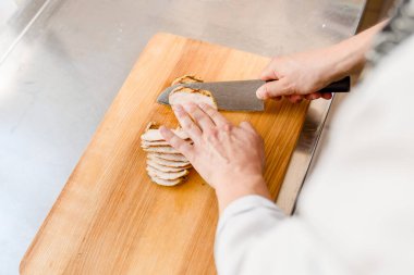 Kesme tahtasındaki çiğ tavuk filetosu. Ramen çorbası için fileto kes. Şef lokantada bıçakla et pişirir..