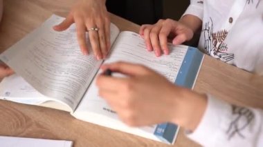 Yabancı bir okulda özel ders, gülümseme, liseli bir kızla haşır neşir olmak. Öğretmen dizüstü bilgisayar kullanarak ana dilin gramerini açıklıyor. Özel hocayla sınava hazırlanıyorum. İngiliz ve İngiliz bayrakları önde.