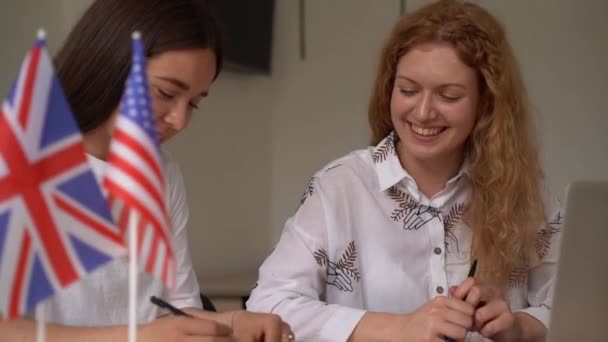 外国学校的私人学习 和一个女学生在一起 老师用笔记本电脑讲解母语语法 准备与导师一起参加考试 前面的英国和英国国旗 — 图库视频影像