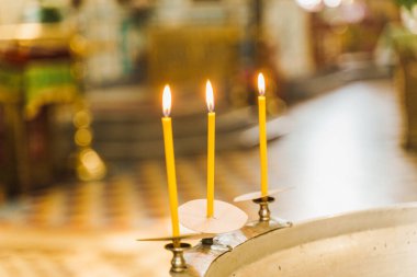 Baptistery ve kilisede bebek için su ve mum yakma ayini. Çocuk için bir yazı tipinde banyo hazırlığı