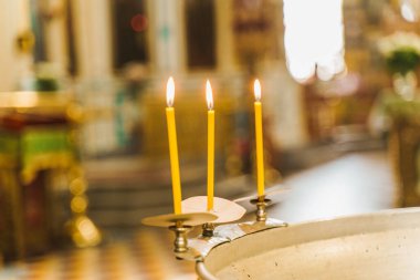 Baptistery ve kilisede bebek için su ve mum yakma ayini. Çocuk için bir yazı tipinde banyo hazırlığı