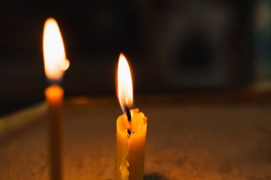 Kilisedeki karanlık arka planda mum yakmak. Trajedi. Ortodoks geleneği ve inancı. Dua etmek için ekipman. İnsanların hayatı için dua et. Tanrıya dua et.