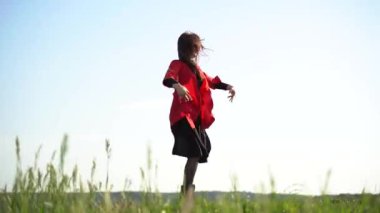 Gürcü kadın, Gürcistan 'ın yeşil tepelerinde kırmızı elbiseyle ulusal dans ediyor. Gürcistan kültür yaşam tarzı.