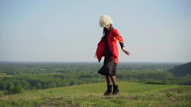 身穿白色木瓜卡哈和红色民族服装的格鲁吉亚女孩跳着名为 Rachuli Acharuli Osuri Shalaxo Mtiuluri 的民族舞蹈 在佐治亚州背景的绿色山丘上 格鲁吉亚文化生活方式 — 图库视频影像