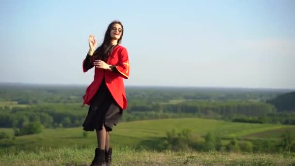 格鲁吉亚妇女身着红色民族服装在格鲁吉亚背景的绿色山丘上跳舞 格鲁吉亚文化生活方式 — 图库视频影像