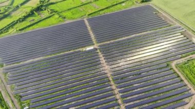 Mavi güneş panelleri olan büyük bir enerji santrali. İnsansız hava aracı görüntüsü. Mavi paneller yerde sıra halinde duruyor. Ev için bedava elektrik. Gezegenin sürdürülebilirliği. Yeşil enerji. Güneş pilleri enerji santrali işi.