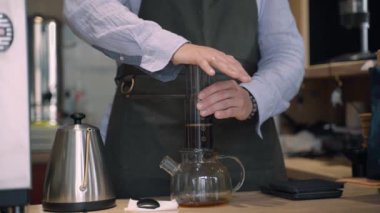 Kahveci kadın tarafından kafede yapılan kahve alternatifi. Barista havacıya baskı yapıyor ve kahve kattona dökülüyor. Kafeye, restoranlara yönlendir.