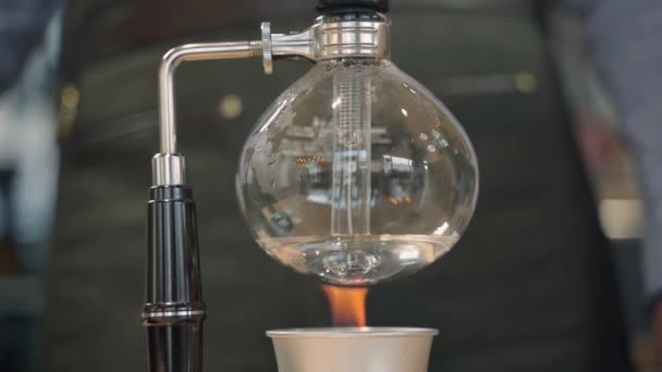 Káva Syphon alternativní způsob výroby v kavárně a kavárně. Průhledná kulatá baňka je ohřívána ohněm zespodu, pak se vaří voda — Stock video