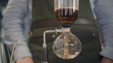 Kahve ve kafede alternatif kahve senfonisi metodu. İskandinav kahvesi demleme yöntemi. Frenonda demleme işlemi. Kahve özel cam çaydanlığa dökülür.
