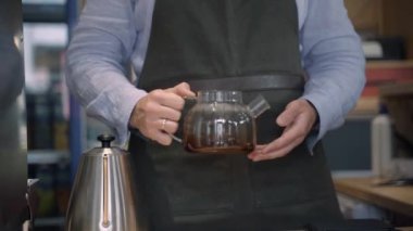 Barista el ele döner ve çaydanlığa kahveyle bakar. Kahve demleme işlemi. İskandinav kahvesi demleme yöntemi