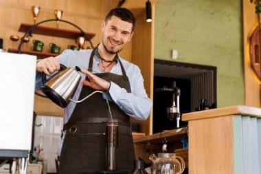 Yakışıklı barista kahveyle uçağa sıcak su dolduruyor ve kameraya bakıp kafede gülümsüyor. Sakallı barista işe yarıyor. Kahveci tarafından kafede yapılan alternatif bir şey. İskandinav kahvesi demleme yöntemi.