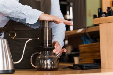 Uçak kahvesi yakın plan: kahve makinesi cihaza baskı yapıyor ve kahve damlaları tencereye uçakları dolduruyor. Alternatif İskandinav kahve demleme yöntemi.
