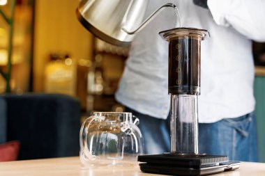 Kafede kahve yapan baristanın yaptığı uçak kahvesine yakın çekim. İskandinav kahvesi demleme yöntemi. Barista Kattle 'ı kullanarak uçağa kahve dolduruyor. Kafeye, restoranlara yönlendir.