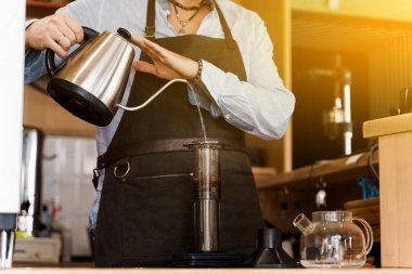 Güneş ışığıyla birlikte uçak kahvesi. Kahveci tarafından kafede yapılan alternatif bir şey. Barista Kattle 'ı tutuyor ve kahveyle uçağa su dolduruyor. İskandinav kahvesi demleme yöntemi.