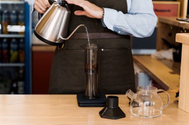 Kahveci kadın tarafından kafede yapılan kahve alternatifi. İskandinav kahvesi demleme yöntemi. Barista Kattle 'ı kullanarak uçağa kahve dolduruyor. Kafeye, restoranlara yönlendir.
