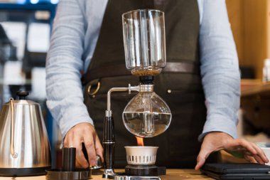 Senfoni cihazıyla demlenen kahve. Sifon, ateşle ısınıyor. Ateşin üstünde demleme fotoğrafı. Alternatif kahve yapma yöntemi.