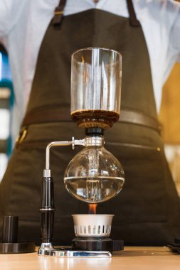 Senfoni cihazıyla demlenen kahve. Sifon, ateşle ısınıyor. Ateşin üstünde demleme fotoğrafı. Alternatif kahve yapma yöntemi. Sosyal ağlarda reklam için dikey fotoğraf