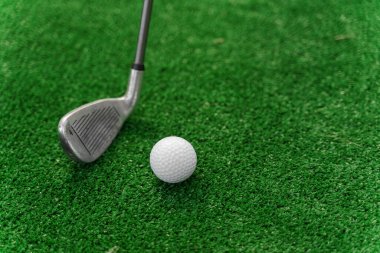 Yeşil çimlerin üzerinde golf oynamak için yakın plan Niblick ve beyaz top. Golf sopası reklamı için sağ taraf boş. Golfte oynamak