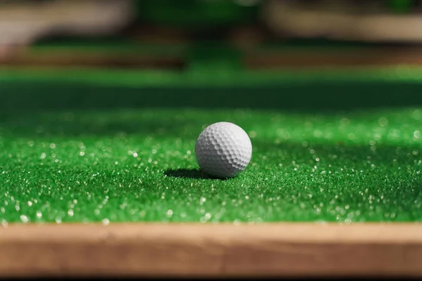 Golf ball on the green grass. Sport mini-golf game.