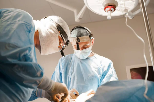 在诊所进行隆胸 整形手术和矫正 外科医生将硅胶植入妇女胸腔 一些戴口罩和手套的专业医生做整形手术 — 图库照片