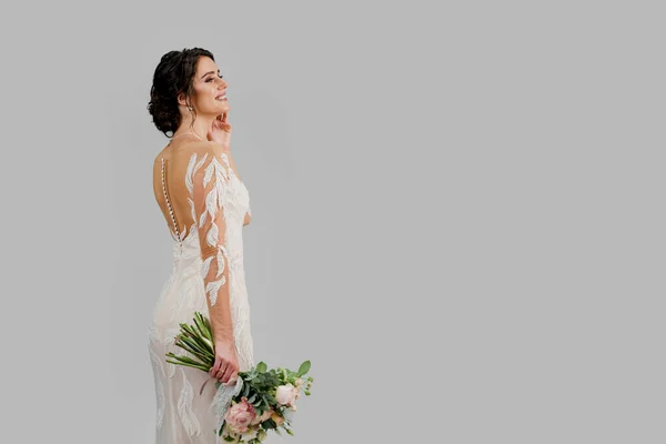 Bride in luxury wedding dress with bouquet in studio on white blank background right side. Advert for social networks for wedding agency and bridal salon
