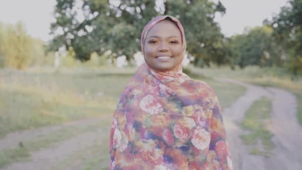 Glad leende och skrattande muslimsk kvinna går runt grön park. Arabiska islam religionskläder. Söt svart flicka ler — Stockvideo
