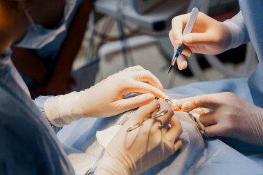 Tıbbi klinikte yüz bölgesinin değiştirilmesi için Blepharoplasty estetik ameliyatı. İki doktor kadınlar için estetik ameliyat yapıyor. Cerrah cerrahi bıçakla bir kesik atar.