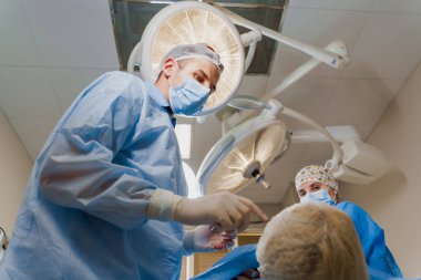 Tıbbi klinikte yüz bölgesinin değiştirilmesi için Blepharoplasty estetik ameliyatı. İki doktor kadınlar için estetik ameliyat yapıyor. Cerrah cerrahi bıçakla bir kesik atar.