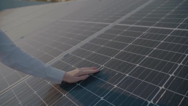 女性は太陽電池パネルの近くを歩き、太陽電池に触れる。家のための無料電気。地球の持続可能性。緑のエネルギー. — ストック動画